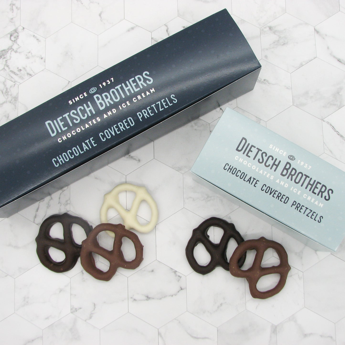 Half pound light blue box of chocolate covered pretzels and one pound dark blue box of chocolate covered pretzels, both with Dietsch Brothers logo on top