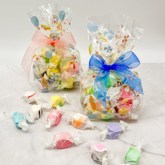 Clear bags with summer designs filled with an assortment of taffy and tied with a colorful bow