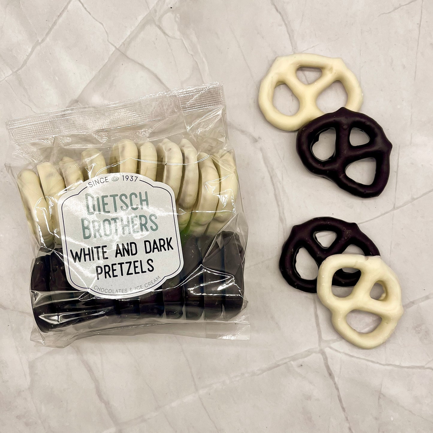 Packaged pretzels with a label reading 'Dietsch Brothers White and Dark Pretzels' on a textured surface.