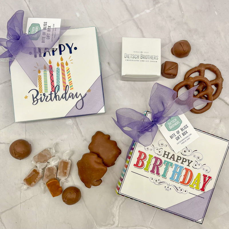 Assorted treat boxes with Happy Birthday design, topped with a colored bow