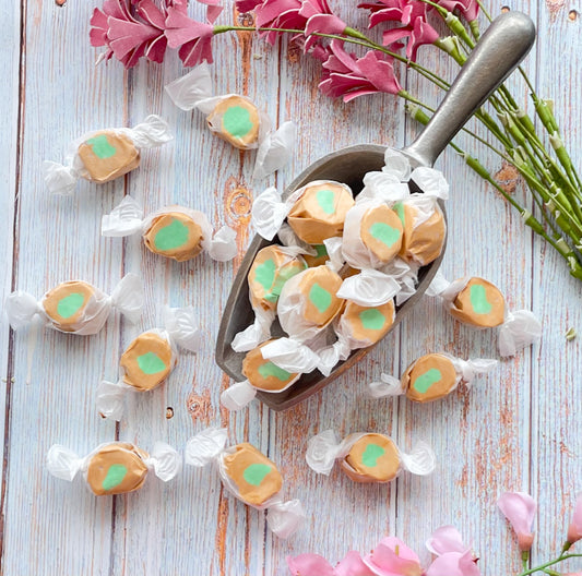 Caramel Apple flavored taffy with a light green center surrounded by a light brown outer layer.
