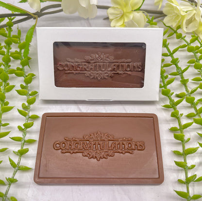 Milk chocolate bar that features "CONGRATULATIONS" across it, and floral borders along the top of the text as well as below it.