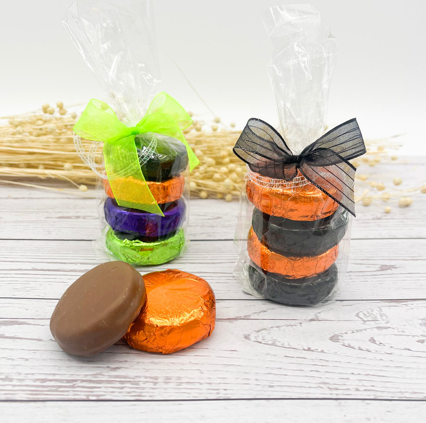 Colorful wrapped chocolate covered Oreo cookies tied with ribbons on a wooden surface