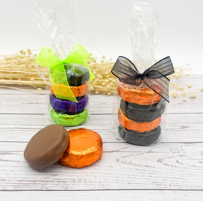 Colorful wrapped chocolate covered Oreo cookies tied with ribbons on a wooden surface