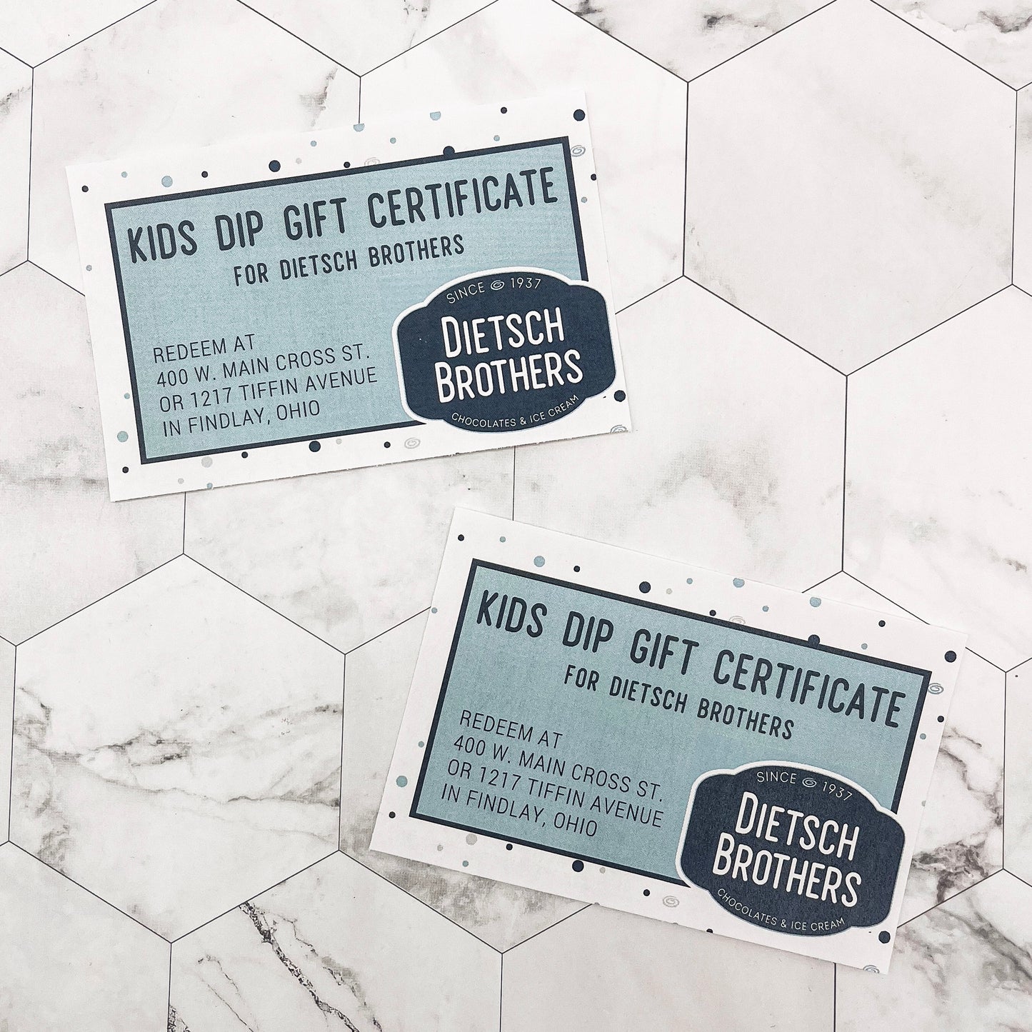 Two Dietsch Brothers Kids Dip Gift Certificates on a marble surface