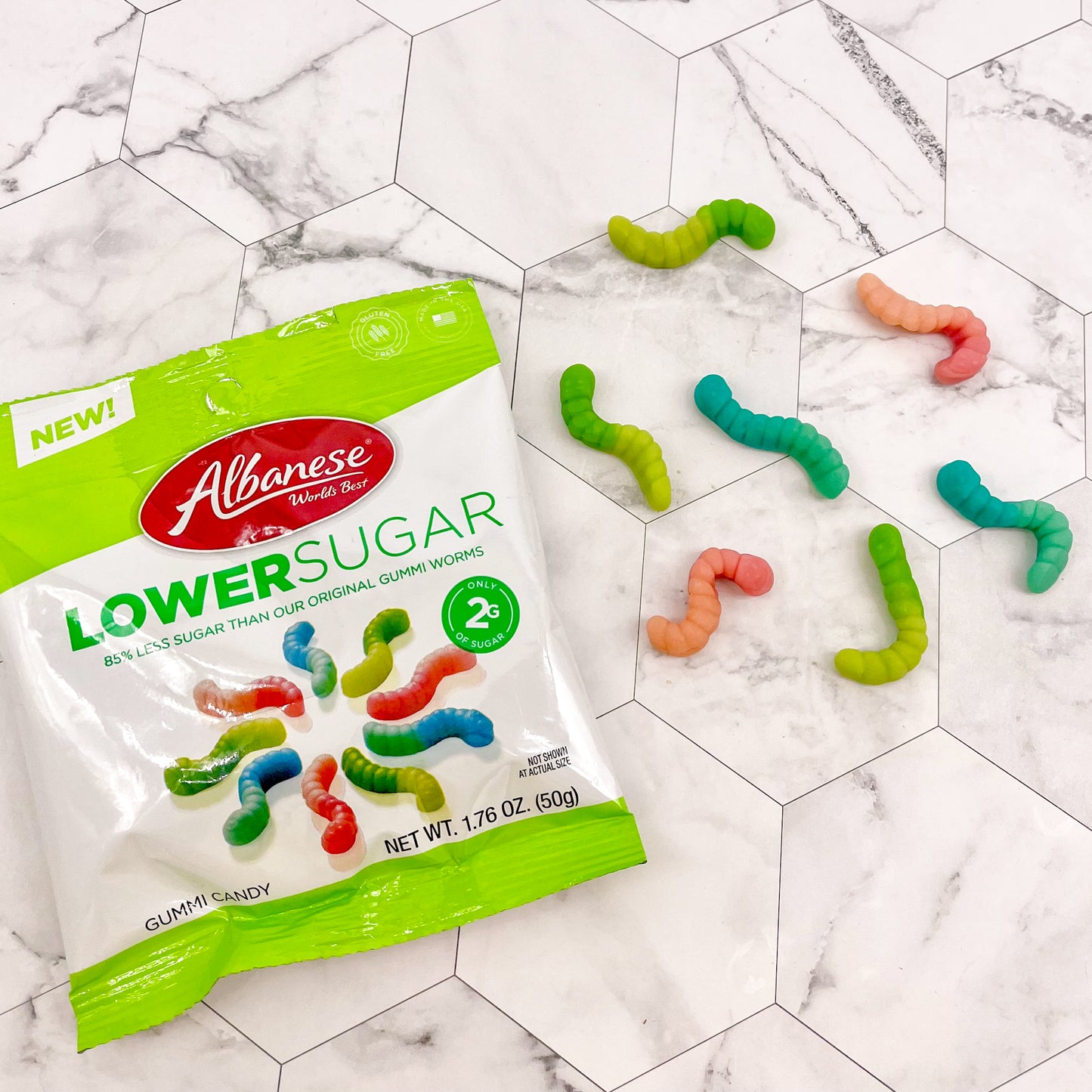 Lower sugar bag of gummi worms with a mixture of blue, green, red and orange gummi worms.