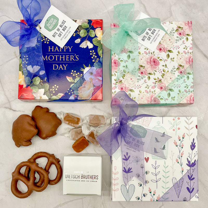 Assorted treat boxes with Happy Mother's Day designs, topped with a colored bow
