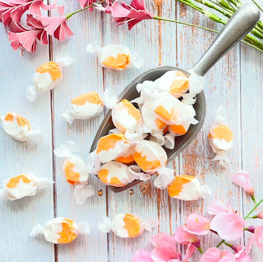 Orange Vanilla taffy that features a combination of white and orange colors mixed together.
