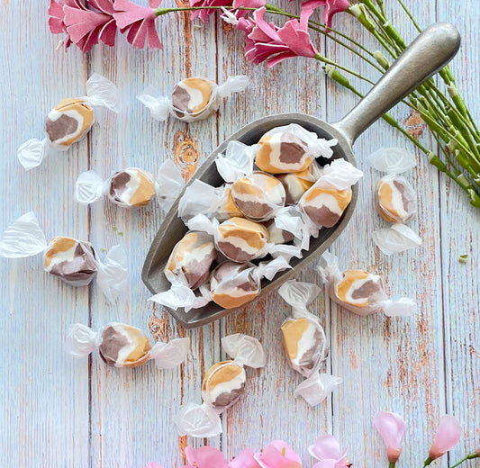 Smores taffy that has a white center surrounded by a light brown on one side and a dark brown on the other side.