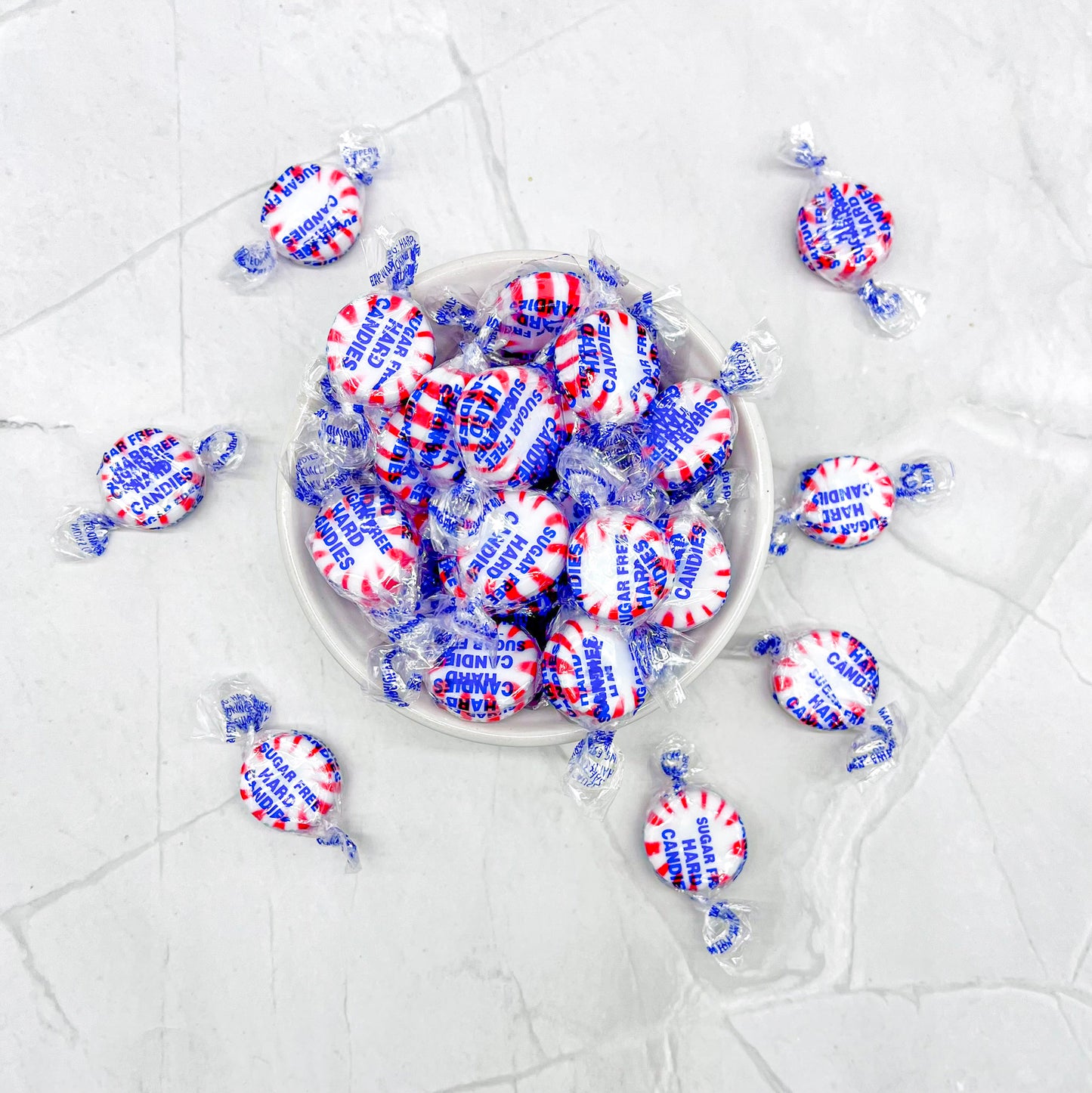 Dish of peppermint wrapped candies spilling over the bowl