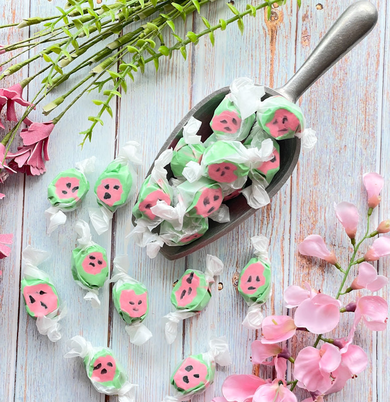 Watermelon flavored taffy that is bright green on outer edges with black dots inside a pink center