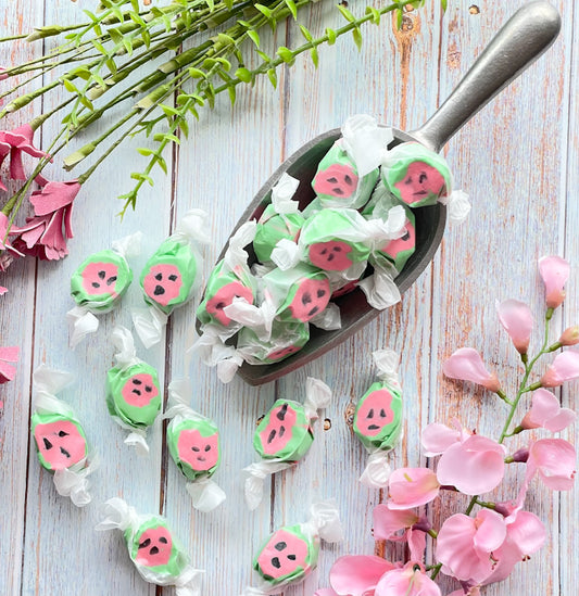 Watermelon flavored taffy that is bright green on outer edges with black dots inside a pink center