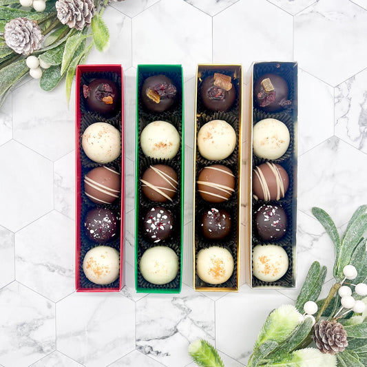 Four boxes of winter truffles on a marble surface with decorative elements.