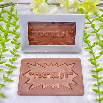 Milk chocolate bar that features raised text "YOU'RE #1" across it, and an outline surrounding the text that has multiple points